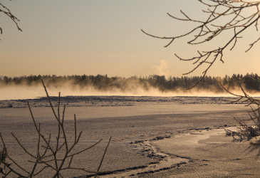 Joki höyryää pakkaskelillä.