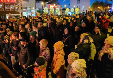 Yleisöä Imatran Koskenpartaalla iltavalaistuksessa talvella.