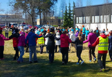 Ihmisiä liikuntatuokiossa urheilutalon pihalla.