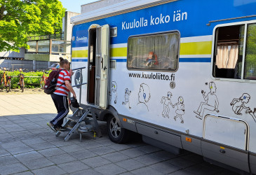 Matkailuauto, johon nousemassa nainen.