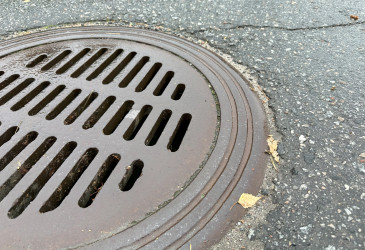 Lähikuva kaivon kannesta sateisella säällä.