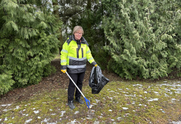 Kaupunginpuutarhuri Erika Luhtanen poimimassa roskia jätesäkkiin.