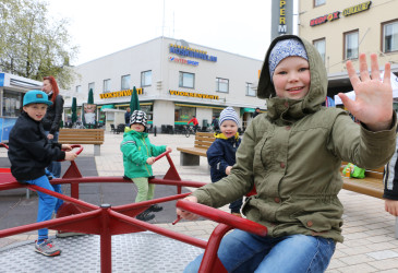 Lapsi vilkuttaa leikkivälineestä Koskenpartaan 20-vuotisjuhlassa.