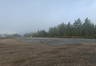 Hiekka-alue, taustalla näkyy kuplahalli ja metsää.