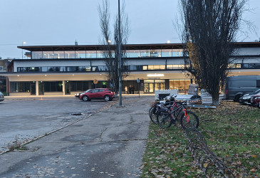 Keskusaseman pihalla autoja ja pyöriä pysäköitynä.