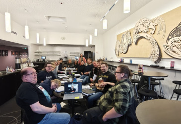 Näyttelijöitä pitkän pöydän ääressä.
