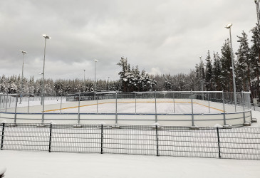 Jääkiekkokaukalo ulkona pienellä lumipeitteellä.