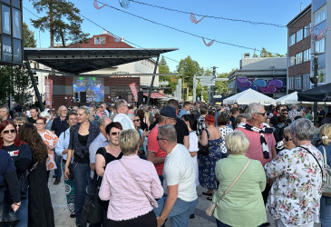 Ihmisiä kesäisellä kävelykadulla.
