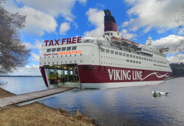 Tekoälyn avulla muokattu kuva, jossa iso Viking Linen laiva on Vuoksella siltana.