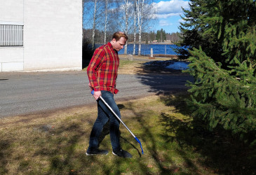 Roskien keruuta maasta roskapihdeillä.