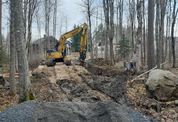 Kaivinkone kaivaa ojaa metsässä.