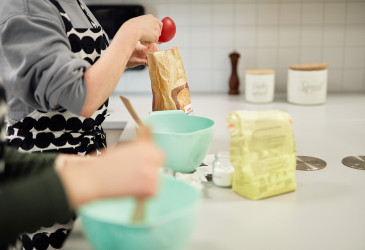 Lapsia leipomassa. Kuva lasten käsistä ja leivontakulhoista.