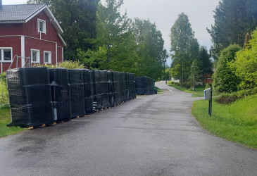 Asuinkadun vieressä mustiin paketteihin pakattuja viemäriputkia.