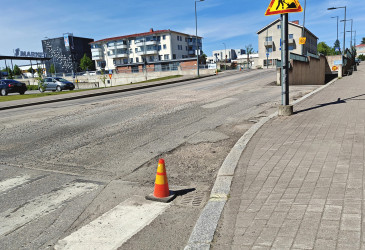 Kadun pinta on jyrsitty, työmaan varoitusmerkki tien reunassa.