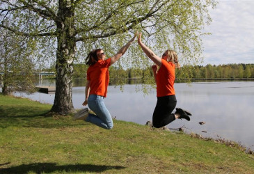 Kaksi ihmistä hyppää ilmaan ja lyö kädet yhteen.