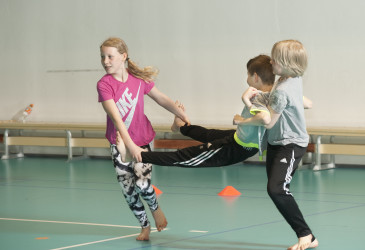 Lapsia leikkimässä liikuntasalissa.