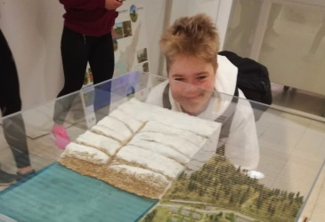 Opiskelija katsoo vitriinissä olevaa jääkausimaisemaa.