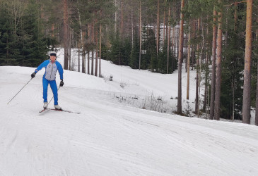 Latua ja hiihtäjä luistelemassa ylämäkeen.