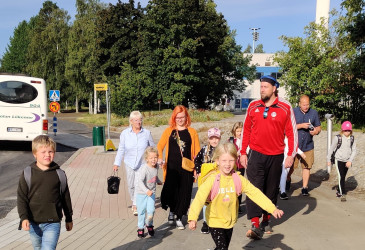 lapsia tulossa kohti kuvaajaa bussilta
