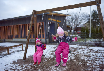 Lapsia keinumassa päiväkodin pihalla.