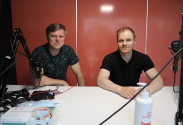kaksi miestä istumassa studion pöydän ääressä.