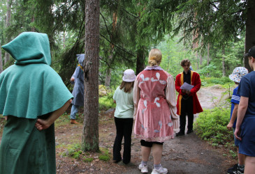 Kruununpuistossa historiallisiksi hahmoiksi pukeutuneita näyttelijöitä ja lapsia.