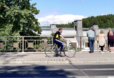 Imatrankoski, sillalla ihmisiä katsomassa koskea ja yksi pyöräilijä.