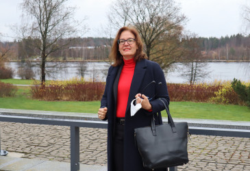 Nainen seisoo kaiteen edessä takanaan joki.