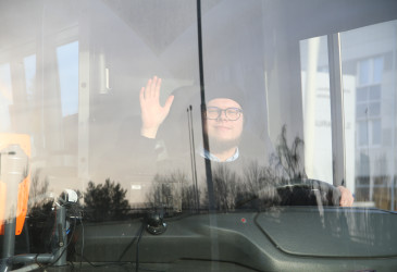 Vilkuttava linja-autokuski ikkunan takaa.