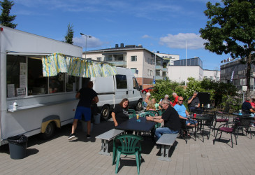 väkeä torikahvilan pöydissä