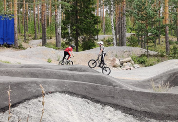 Kaksi lasta pyöräilemässä pumptrackillä