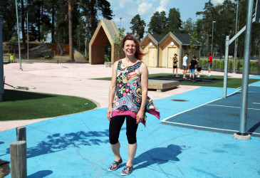 Kirsi etualalla taustalla lapsia Mansikkalan koulun pihalla.