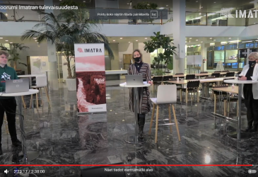 panelistit seisomassa kaupungintalon aulassa.