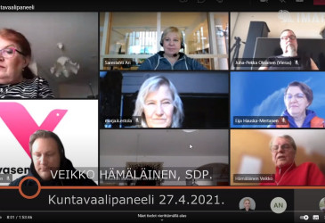 Kuvakaappaus Youtube-lähetyksestä, jossa näkyvät seitsemän panelistia ja juontaja.