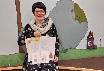 Kirjastovirkailija Tiina Rossi esittelee lukudiplomeita.