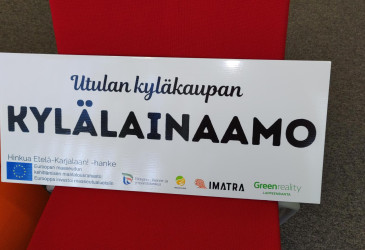 Utulan kylälainaamon kyltti.