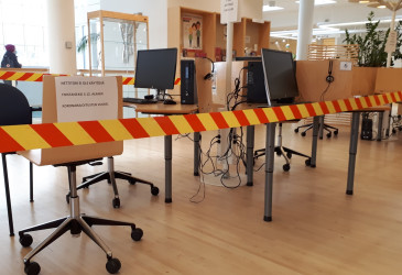 Kirjaston asiakastietokoneita, joiden edessä sulkunauha.