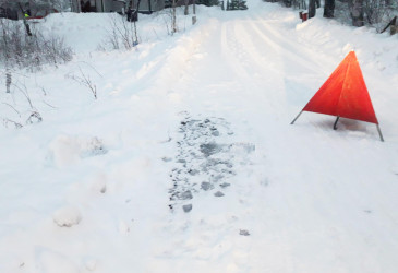 kastunutta lunta tiellä ja varoituskolmio.