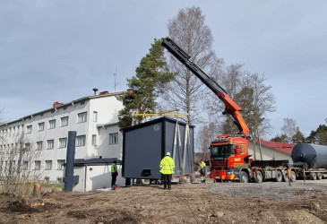 koulurakennus, kontti ja nosturi.