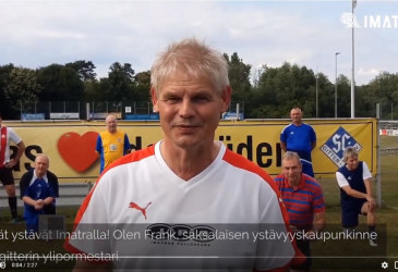 Etualalla pormestari ja jalkapallojoukkue ryhmittyneenä hänen taakseen.