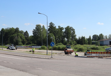 Asfaltointityömaalla kaksi työntekijää.