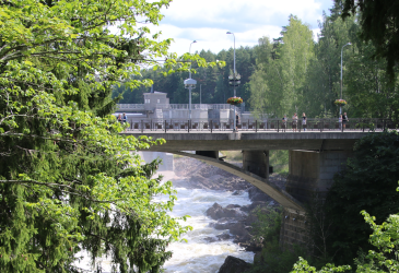 silta lehtipuiden ympäröimänä, koski kuohuu alla.