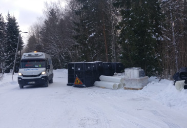 Pakettiauto ja viemäriputkia kujalla.