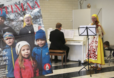 Heini Vesterinen viulussa ja Johannes pianossa sekä kotimaa-lehden kansi lisättynä kuvaan, kannessa koko perhe