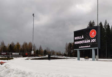Hiihtolatu sekä kyltti, jossa lukee: Meillä hiihdetään jo!