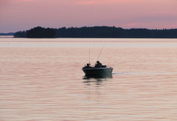 Vene illalla tyynellä järvellä.