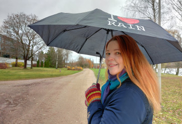 Kati Bragge kävelee sateenvarjon kanssa.