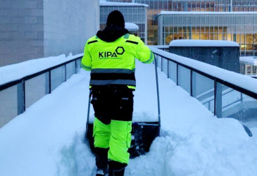 Työmies kolaa lunta.