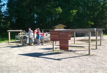 Matonpesupaikka, jossa kolme ihmistä on pesemässä mattoja.