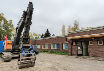 Työkone, taustalla Mansikkalan päiväkotirakennus.
